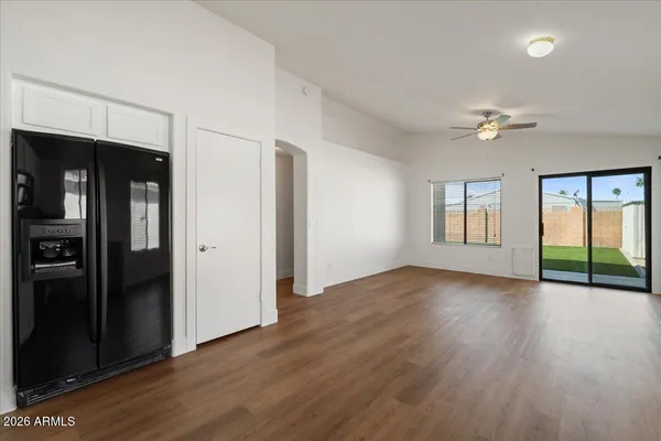 a view of an empty room with window and wooden floor