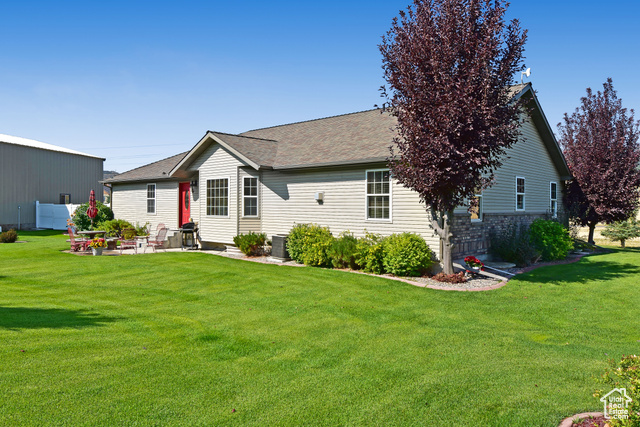 1500 Fish Creek Road Bancroft, ID 83217 - Photo 37 of 45 Rear view of house with a lawn, a patio area, and roof with shingles