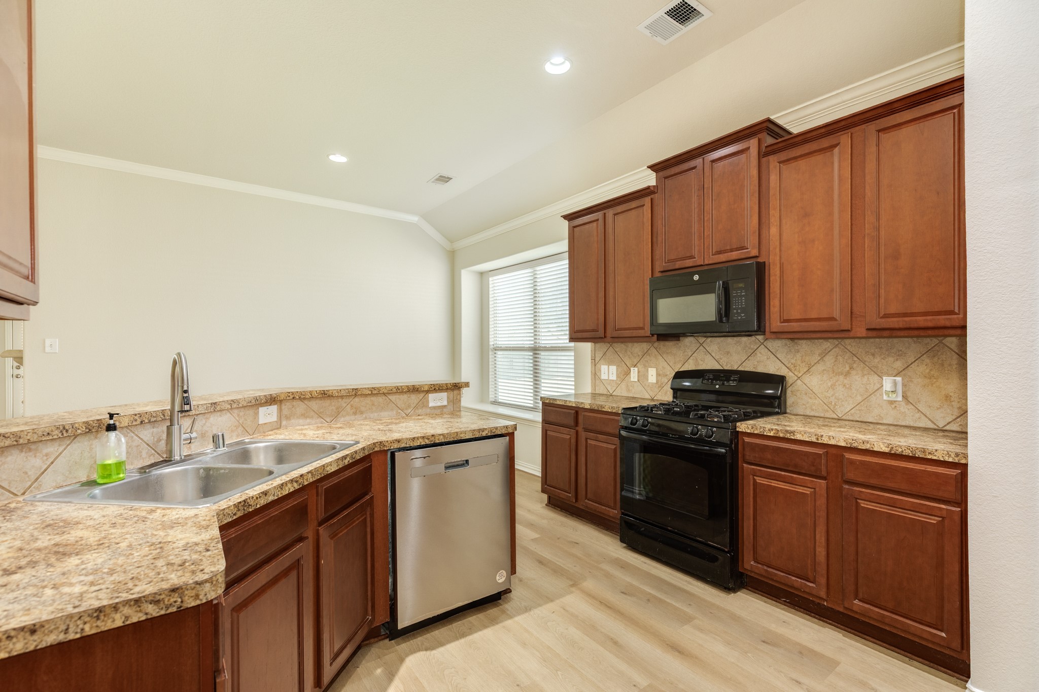 13417 Star Creek Lane Rosharon, TX 77583 - Photo 9 of 41 The tile backsplash makes the cabinets stand out, and the engineered wood flooring seamlessly connects the kitchen and family area.