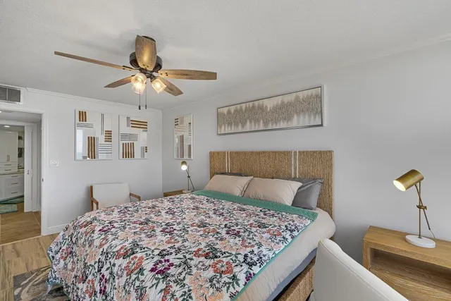 a bedroom with a large bed and a chandelier