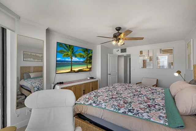 a living room with a bed furniture flat screen tv and a large window