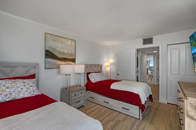 a bedroom with two beds and painting on the wall