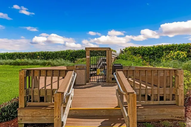 a view of a balcony with wooden floor & fence