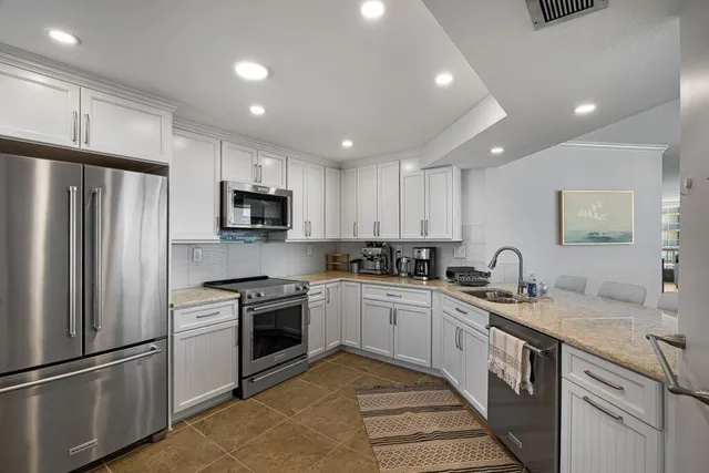 a kitchen with a sink stainless steel appliances and cabinets