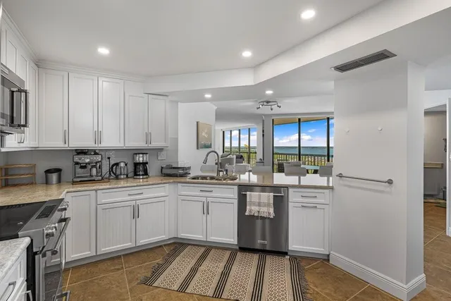 a kitchen with white cabinets sink and stove