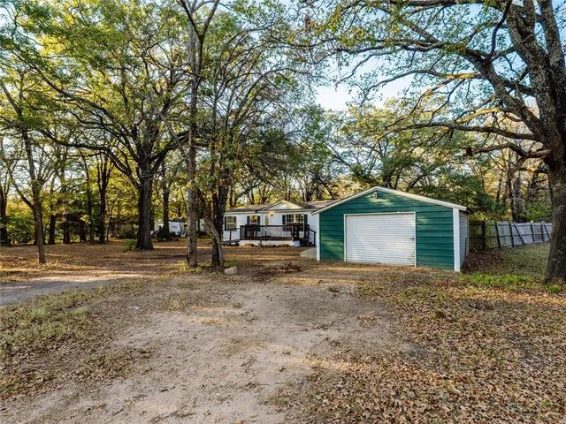 a white house that has a tree in front of it
