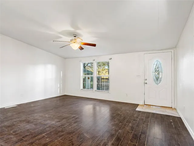 an empty room with wooden floor and window