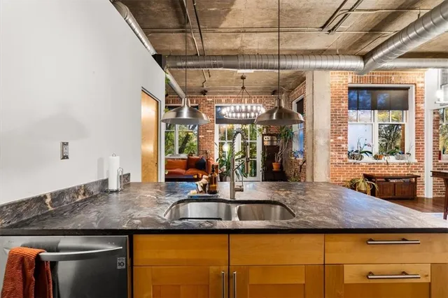 a kitchen with kitchen island granite countertop a sink and a refrigerator