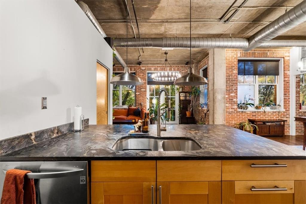 3235 Roswell Road Northeast, Unit 609 Atlanta, GA 30305 - Photo 11 of 30 a kitchen with kitchen island granite countertop a sink and a refrigerator