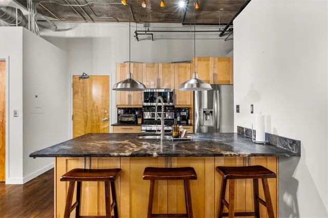 a kitchen with kitchen island granite countertop a table chairs and a large window