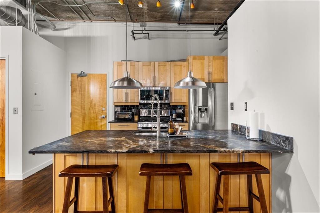 3235 Roswell Road Northeast, Unit 609 Atlanta, GA 30305 - Photo 12 of 30 a kitchen with kitchen island granite countertop a table chairs and a large window