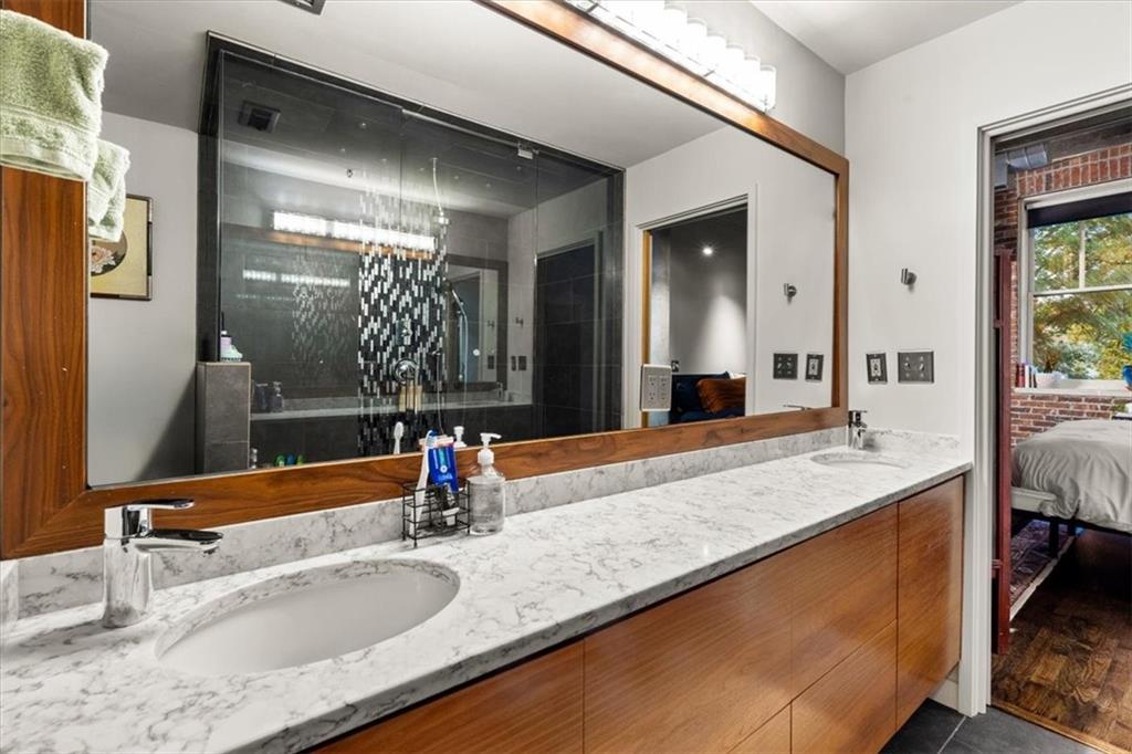 3235 Roswell Road Northeast, Unit 609 Atlanta, GA 30305 - Photo 19 of 30 a bathroom with a granite countertop sink and a mirror