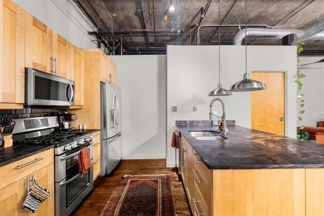 a kitchen with stainless steel appliances granite countertop a sink and a stove