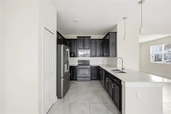 a large kitchen with granite countertop a stove top oven a sink dishwasher and wooden cabinets
