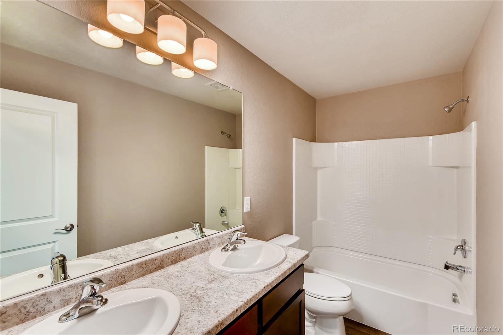 7132 Shavano Circle Frederick, CO 80504 - Photo 14 of 14 a bathroom with a granite countertop sink and a mirror