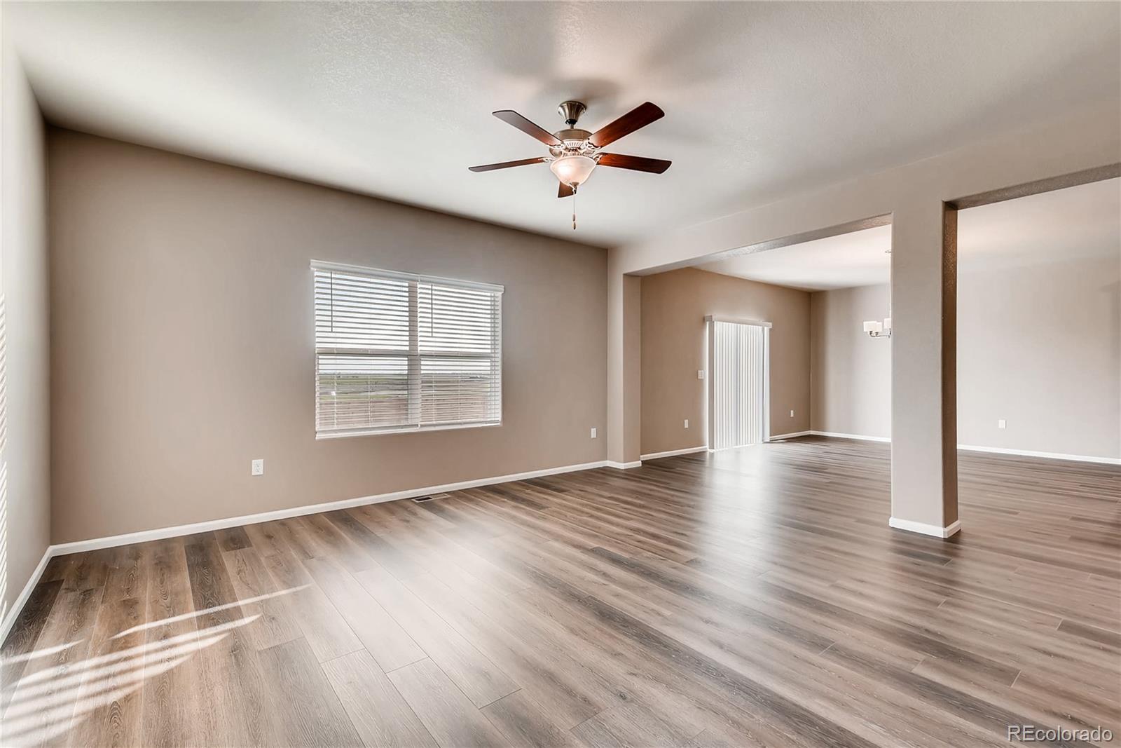 7132 Shavano Circle Frederick, CO 80504 - Photo 3 of 14 a view of an empty room with wooden floor and a window