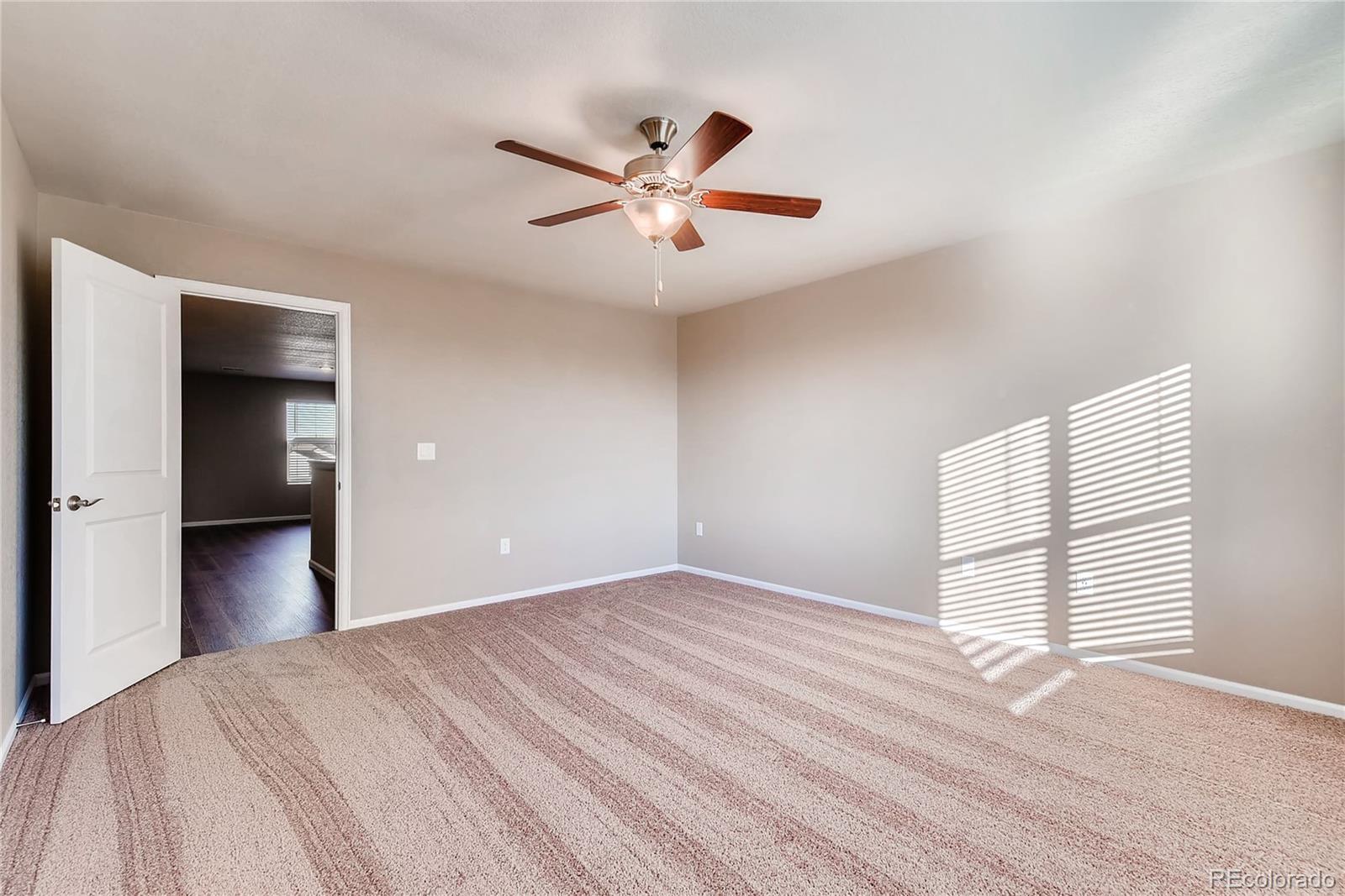 7132 Shavano Circle Frederick, CO 80504 - Photo 10 of 14 a view of empty room with wooden floor and fan