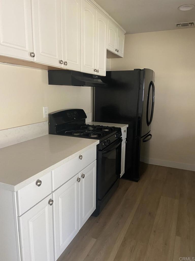 917 Broadview Street Spring Valley, CA 91977 - Photo 4 of 14 a kitchen with granite countertop white cabinets and black appliances