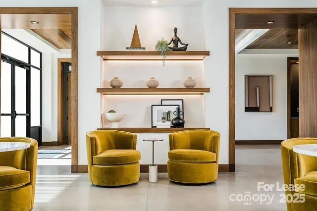 a living room with couches and kitchen view with wooden floor