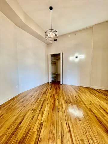a view of a room with wooden floor and ceiling fan