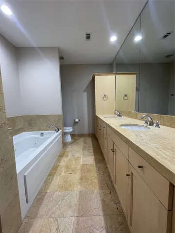 a bathroom with a tub sink and mirror