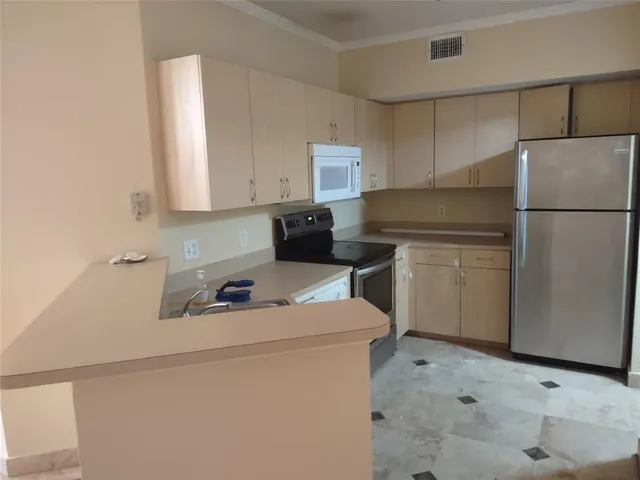 a kitchen with a refrigerator sink stove and white cabinets