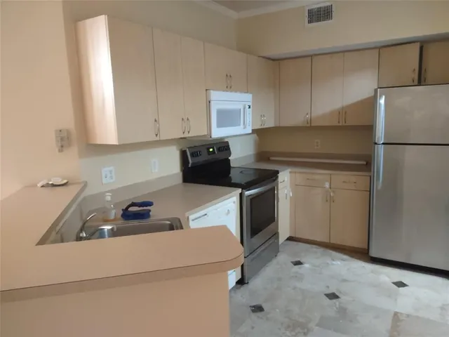 a kitchen with a refrigerator sink and cabinets
