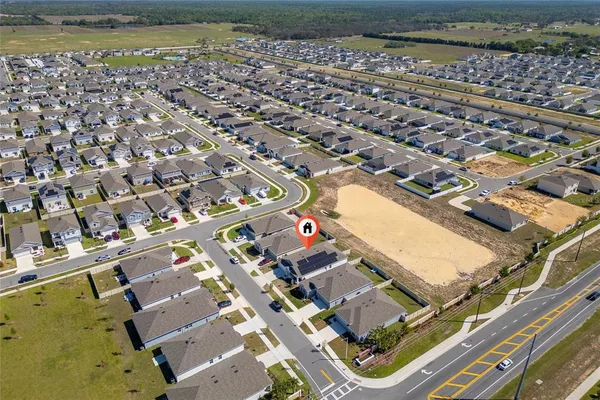 an aerial view of residential houses with outdoor space and ocean view