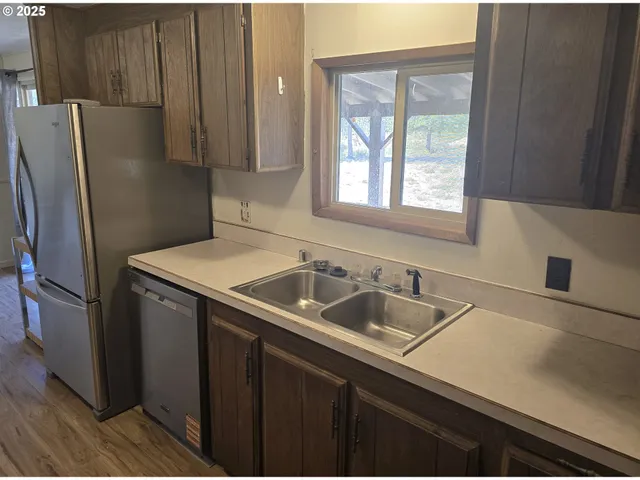 a kitchen with a sink a refrigerator and cabinets