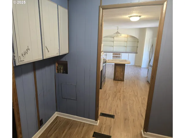 a view of a hallway with wooden floor and staircase