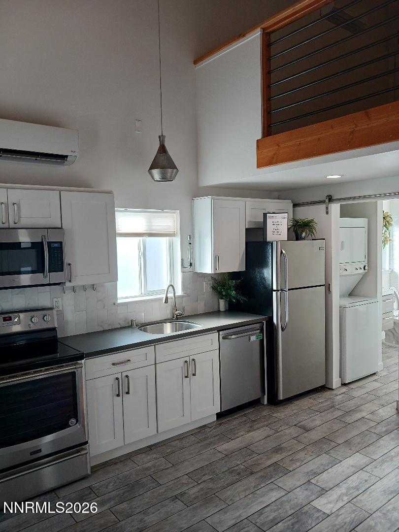831 Ryland Street Reno, NV 89502 - Photo 3 of 26 a kitchen with stainless steel appliances granite countertop a refrigerator a sink dishwasher a stove and white cabinets with wooden floor