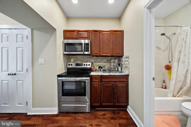 a kitchen with stainless steel appliances granite countertop a stove and a microwave