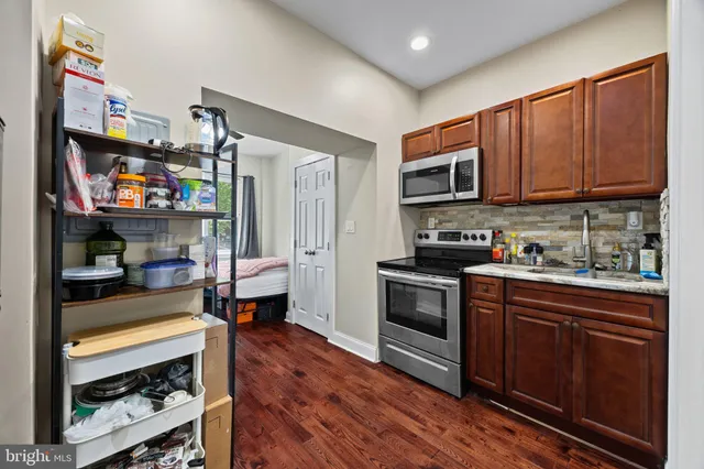 a kitchen with stainless steel appliances granite countertop a refrigerator stove and sink