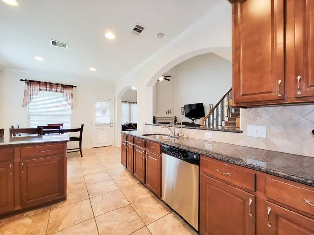 a kitchen with stainless steel appliances granite countertop a sink and cabinets