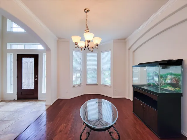 a view of a livingroom with furniture wooden floor and a chandelier