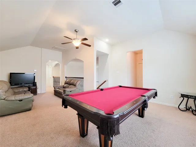 a room with pool table and windows