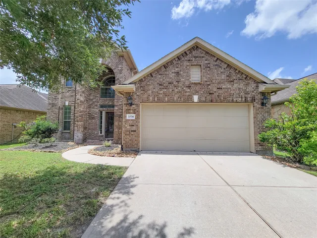 a front view of a house with a yard and tree