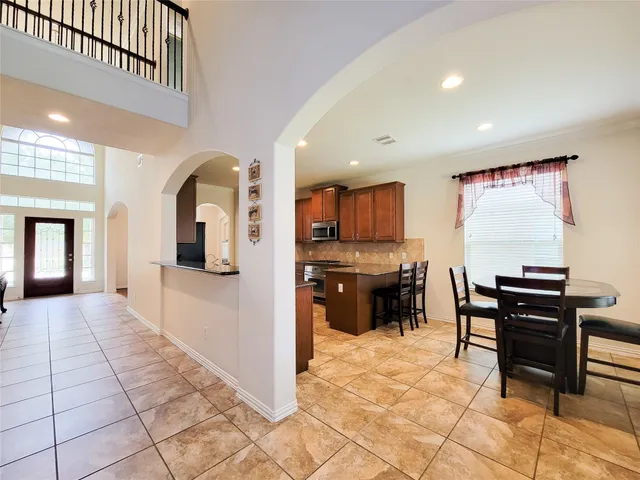 a kitchen with stainless steel appliances kitchen island granite countertop a refrigerator and cabinets
