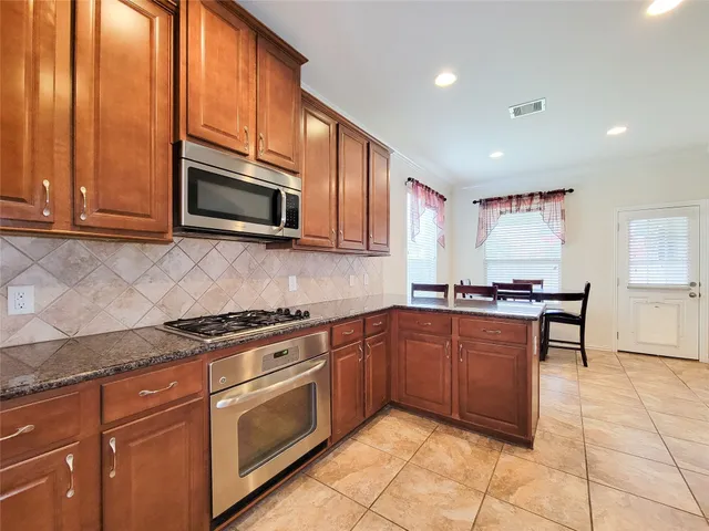 a kitchen with stainless steel appliances granite countertop a stove microwave and sink