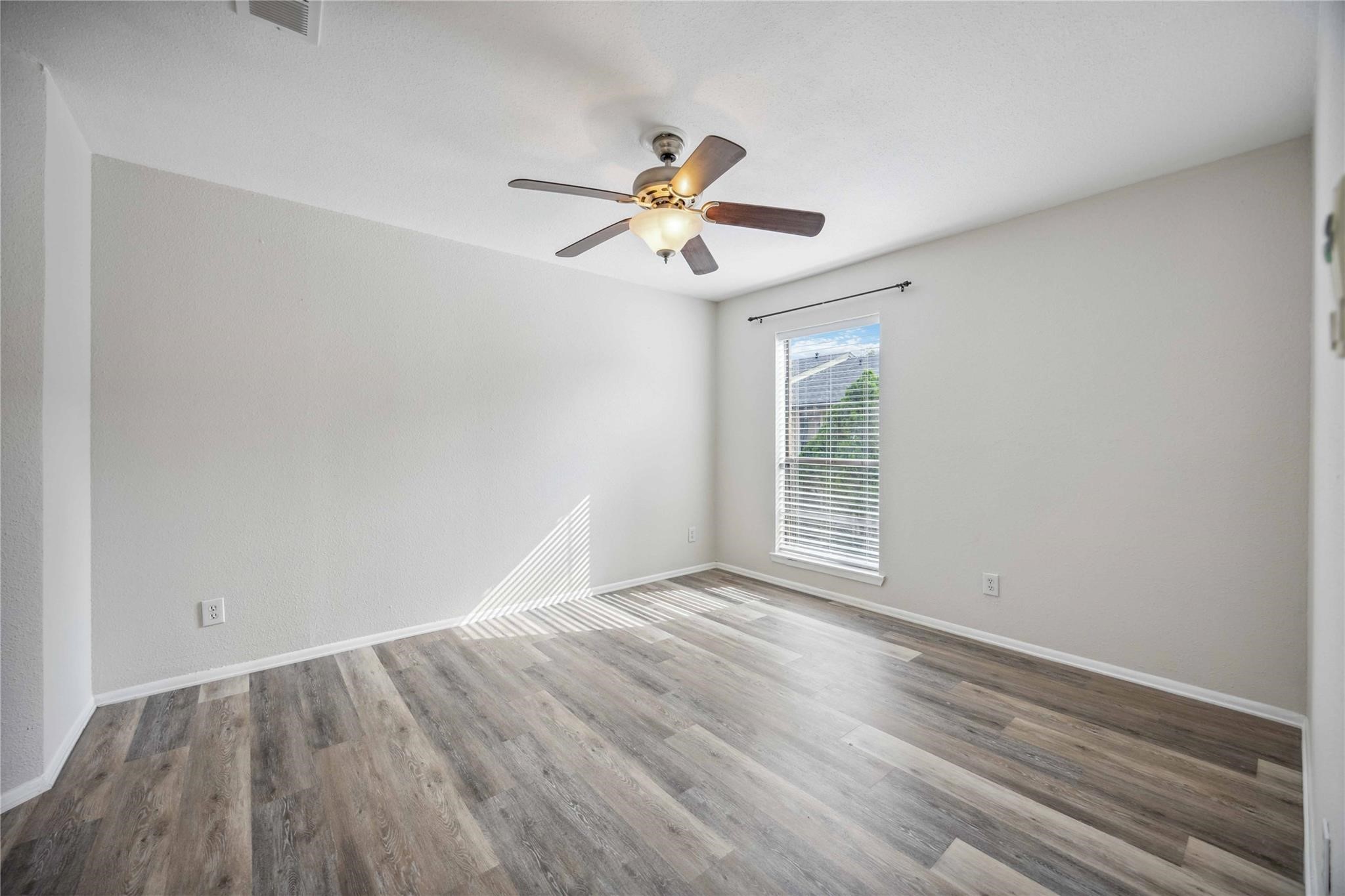 15534 Zabolio Drive, Unit 241 Houston, TX 77598 - Photo 12 of 21 a view of a room with wooden floor ceiling fan and window