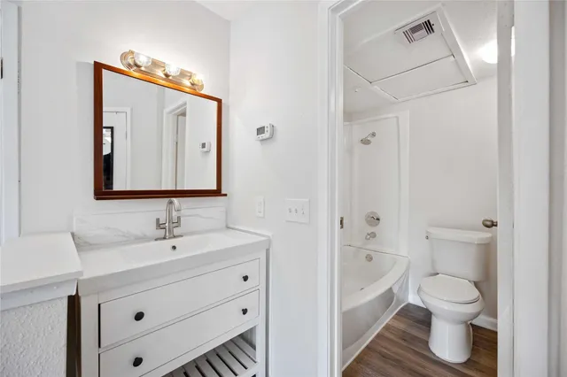 a bathroom with a toilet sink a mirror and vanity