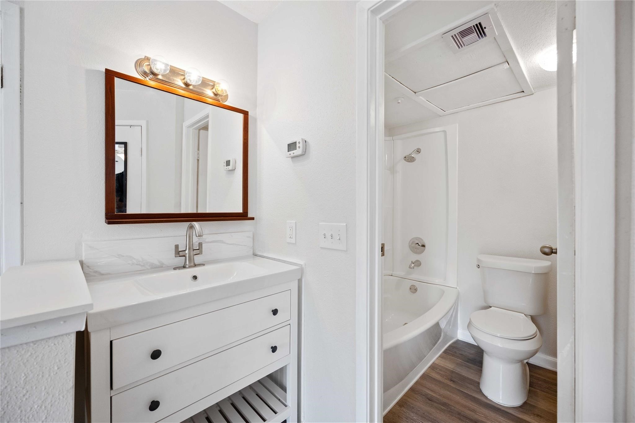 15534 Zabolio Drive, Unit 241 Houston, TX 77598 - Photo 15 of 21 a bathroom with a toilet sink a mirror and vanity