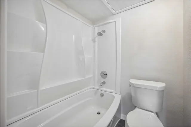 a white toilet sitting next to a bath tub