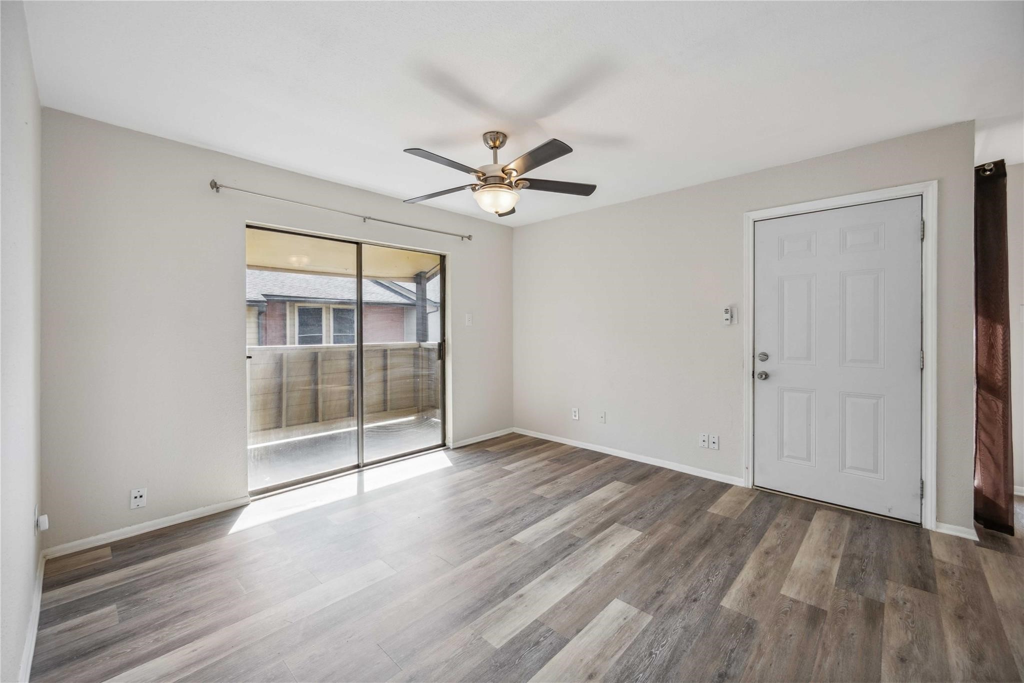 15534 Zabolio Drive, Unit 241 Houston, TX 77598 - Photo 3 of 21 an empty room with wooden floor and door