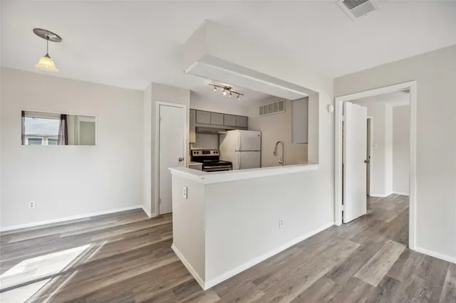 a kitchen with a refrigerator and a stove top oven