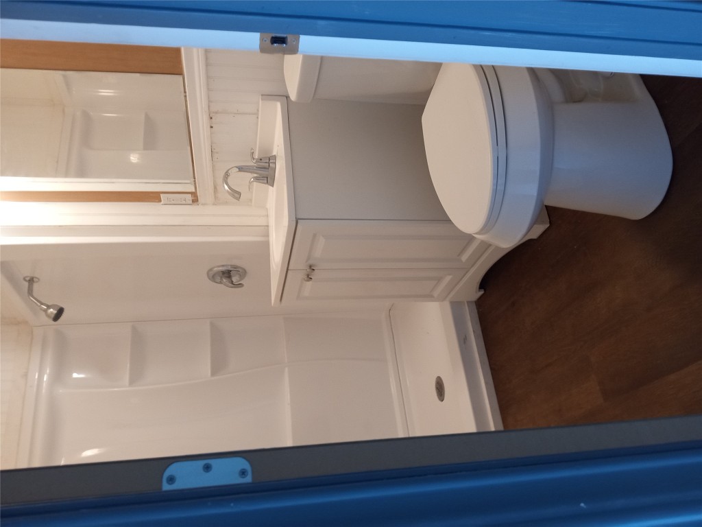 1505 Oreilly Court, Unit C Austin, TX 78734 - Photo 17 of 19 Full bathroom featuring wood finished floors, a stall shower, and vanity