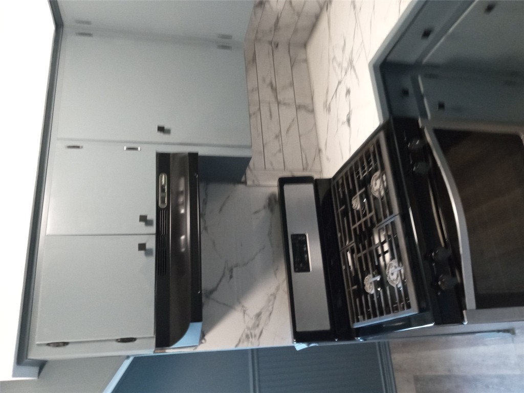 1505 Oreilly Court, Unit C Austin, TX 78734 - Photo 2 of 19 Kitchen featuring range, ventilation hood, wood finished floors, and backsplash