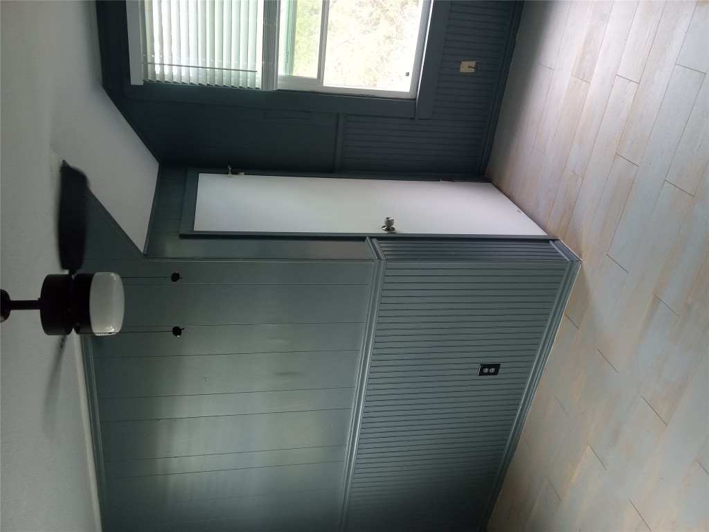 1505 Oreilly Court, Unit C Austin, TX 78734 - Photo 4 of 19 Empty room with light wood-style flooring, a ceiling fan, wood walls, and lofted ceiling