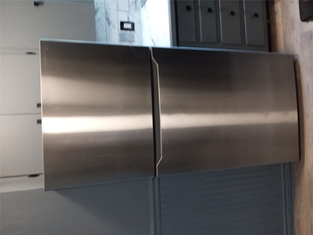1505 Oreilly Court, Unit C Austin, TX 78734 - Photo 8 of 19 Kitchen view of freestanding refrigerator, wood finished floors, light countertops, and gray cabinetry