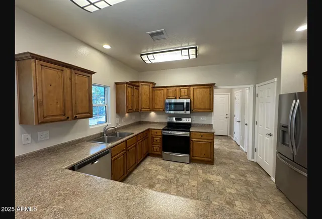a kitchen with stainless steel appliances granite countertop a refrigerator and a sink